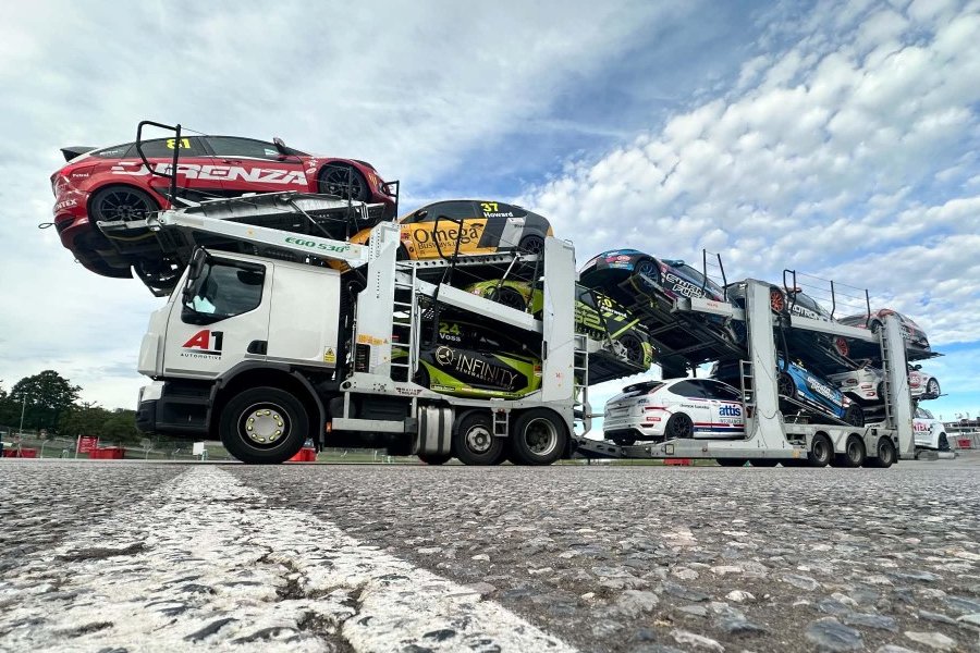 A1 Automotive transporter on a circuit, loaded with touring cars, low angle